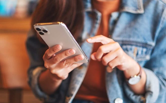 Kvinder indtaster elevtilfredshedsmålinger på telefonen