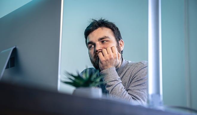 Mand sidder eftertænksom og læser om Quiet quitting | Et stille oprør mod det pressede arbejdsliv